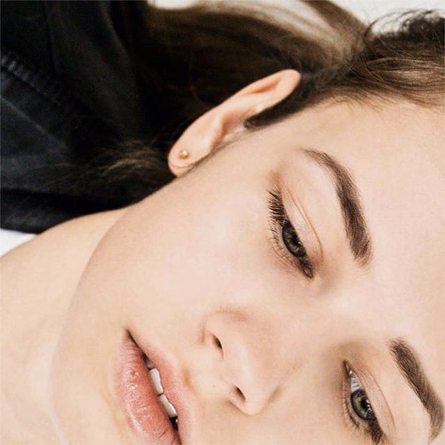 A close-up of a woman's face showcasing soft, natural skin and a serene expression.